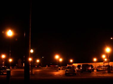 Parking lot with post lamps with arorn globes and HPS lights.